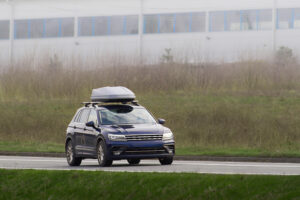 Family car with roof cargo box on highway