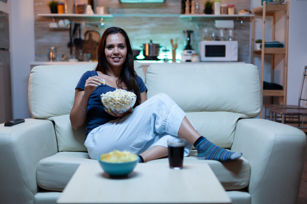 Lady resting with snaks watching a movie