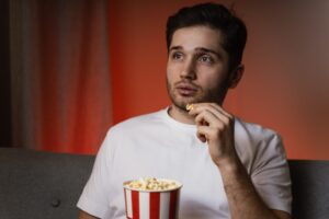 man-watching-tv-eating-popcorn-1024x683-1