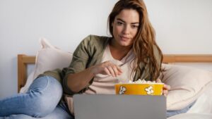 woman-eating-popcorn-while-watching-movie-laptop-1024x576-1
