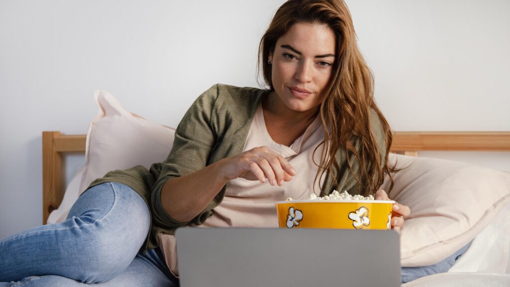 woman-eating-popcorn-while-watching-movie-laptop-1024x576-1